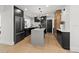 Bright kitchen showcasing a central island, stainless steel refrigerator, black cabinetry, and a contemporary lighting fixture at 407 41St Ave, St Pete Beach, FL 33706