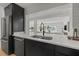 Contemporary kitchen featuring black cabinets and marble countertops open to the living room overlooking the waterfront at 407 41St Ave, St Pete Beach, FL 33706