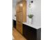 Close-up view of kitchen featuring wooden storage cabinets, black countertops, white backsplash, and stylish modern lighting at 407 41St Ave, St Pete Beach, FL 33706