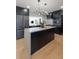 Open-concept kitchen with center island, stainless steel appliances, modern cabinets, and stylish hardwood flooring at 407 41St Ave, St Pete Beach, FL 33706