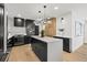 A stylish kitchen with a center island, designer lighting, white tile backsplash, and sleek, built-in black appliances at 407 41St Ave, St Pete Beach, FL 33706