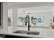 Kitchen with marble countertops and a sink with a faucet overlooking the beautiful waterfront with boats docked alongside houses at 407 41St Ave, St Pete Beach, FL 33706