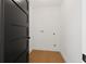 Laundry room with white walls and light wood floors, and black door at 407 41St Ave, St Pete Beach, FL 33706