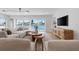 Living room with waterfront view, modern furniture, and stylish entertainment center at 407 41St Ave, St Pete Beach, FL 33706