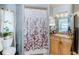 Clean bathroom with floral shower curtain and wood vanity at 4573 Deltona Blvd, Spring Hill, FL 34606