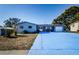 Ranch style home with brick entryway, attached garage, and large driveway at 4573 Deltona Blvd, Spring Hill, FL 34606