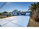 Front view of a ranch home with a large blue driveway at 4573 Deltona Blvd, Spring Hill, FL 34606