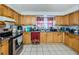 Kitchen boasts light wood cabinets, stainless steel appliances, and tile floors at 4573 Deltona Blvd, Spring Hill, FL 34606