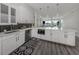 Modern kitchen with white cabinets, quartz countertops, and stainless steel appliances at 507 Tamiami N Trl # 201, Venice, FL 34285