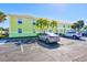 Light yellow building exterior with parking and palm trees at 5116 Beach Se Dr # D, St Petersburg, FL 33705