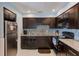 Modern kitchen with dark wood cabinets, granite countertops, and stainless steel appliances at 5116 Beach Se Dr # D, St Petersburg, FL 33705