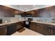 Modern kitchen featuring dark wood cabinets, granite counters, and stainless steel appliances at 5116 Beach Se Dr # D, St Petersburg, FL 33705