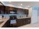 Modern kitchen with dark wood cabinets, granite counters, and stainless steel appliances at 5116 Beach Se Dr # D, St Petersburg, FL 33705