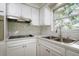 Modern kitchen with white cabinets, stainless steel appliances, and marble backsplash at 5219 E 17Th Ave, Tampa, FL 33619