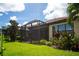 Landscaped backyard showcasing a home with a screened patio at 5548 Sentiero Dr, Nokomis, FL 34275