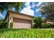 Low-angle view of house, showcasing garage and landscaping at 5548 Sentiero Dr, Nokomis, FL 34275