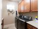 Laundry room with washer, dryer, and upper cabinets at 5548 Sentiero Dr, Nokomis, FL 34275