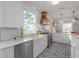 White kitchen features a farmhouse sink, stainless steel appliances, and wood hood at 5610 N Seminole Ave, Tampa, FL 33604