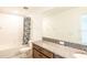 Clean bathroom with granite vanity, tub shower, and large mirror at 7815 Bronze Oak Dr, Wesley Chapel, FL 33545