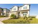 Two-story house with light-colored exterior, a two-car garage, and lush landscaping at 7815 Bronze Oak Dr, Wesley Chapel, FL 33545