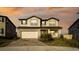Two-story house with white siding, a large garage, and a well-manicured lawn at 7815 Bronze Oak Dr, Wesley Chapel, FL 33545