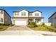 Two-story house with light-colored exterior, a two-car garage, and landscaping at 7815 Bronze Oak Dr, Wesley Chapel, FL 33545