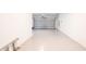Garage with open door, white walls, and epoxy flooring at 7815 Bronze Oak Dr, Wesley Chapel, FL 33545