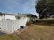 Side view of the home showcasing the block wall and landscaping at 1002 N Pebble Beach Blvd # 1002, Sun City Center, FL 33573