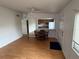 Open living room with wood floors flowing into a dining area and kitchen at 1002 N Pebble Beach Blvd # 1002, Sun City Center, FL 33573