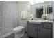 Updated bathroom with gray vanity, white toilet and shower at 1205 Chevy Chase Dr, Sun City Center, FL 33573