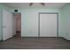 Bedroom with light green walls, wood-look flooring, and access to hallway at 1205 Chevy Chase Dr, Sun City Center, FL 33573