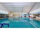 Indoor heated swimming pool with benches and mural at 1205 Chevy Chase Dr, Sun City Center, FL 33573