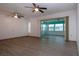 Spacious living room with wood-look floors and sliding glass doors at 1205 Chevy Chase Dr, Sun City Center, FL 33573