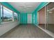 Bright sunroom with teal walls, wood-look flooring, and sliding glass doors at 1205 Chevy Chase Dr, Sun City Center, FL 33573