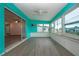 Sunroom with teal walls, wood-look floors and multiple windows at 1205 Chevy Chase Dr, Sun City Center, FL 33573