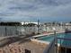 Community pool with waterfront views and patio furniture at 12500 Capri Cir N # 302, Treasure Island, FL 33706