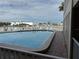 Community pool with water view and lounge chairs at 12500 Capri Cir N # 302, Treasure Island, FL 33706