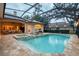 Enclosed pool and spa with lounge chairs under a glass roof at 16312 Dunlindale Dr, Lithia, FL 33547
