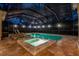 Night view of a pool and spa with a covered patio at 16312 Dunlindale Dr, Lithia, FL 33547