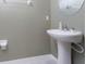 Small bathroom with pedestal sink and round mirror at 16719 Delia St, Wimauma, FL 33598