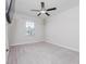 Spacious bedroom with window, ceiling fan and wall-mounted TV at 16719 Delia St, Wimauma, FL 33598