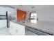Kitchen island with granite countertop, double sink, and stainless steel dishwasher at 16719 Delia St, Wimauma, FL 33598