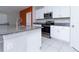White kitchen cabinets, granite countertop island, and stainless steel appliances at 16719 Delia St, Wimauma, FL 33598