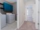 Bright laundry room with washer, dryer, and teal cabinets at 16719 Delia St, Wimauma, FL 33598