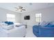Living room with light colored sofa, blue accent chair, and ceiling fan at 16719 Delia St, Wimauma, FL 33598
