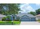 Beautiful blue home with a two-car garage and lush landscaping at 2015 Wexford Green Dr, Valrico, FL 33594