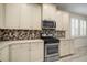 Modern kitchen with stainless steel appliances and stylish backsplash at 211 Shell Creek Ct, Apollo Beach, FL 33572