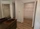 Bathroom with double sinks, walk-in closet, and wood flooring at 2280 Toniwood Ln, Palm Harbor, FL 34685