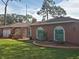 House exterior with unique painted windows, landscaping, and a large yard at 2280 Toniwood Ln, Palm Harbor, FL 34685