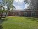 Single story home with orange exterior and landscaped lawn at 2280 Toniwood Ln, Palm Harbor, FL 34685